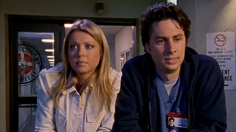 Dani and J.D. leaning together on the railing outside Sacred Heart Hospital on "Scrubs" (2001-2010)