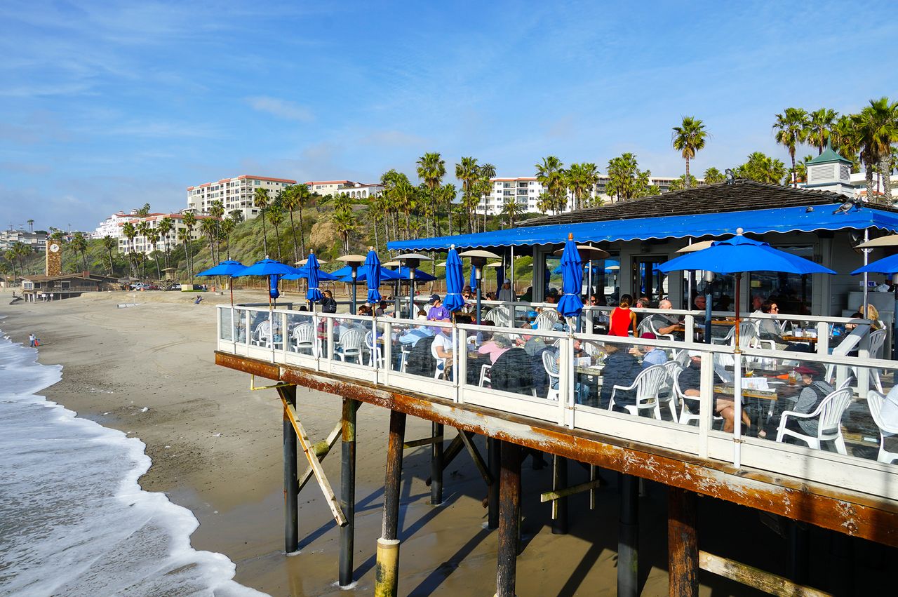 Seaside restaurant with outdoor dining on a pier overlooking a beach in San Clemente California