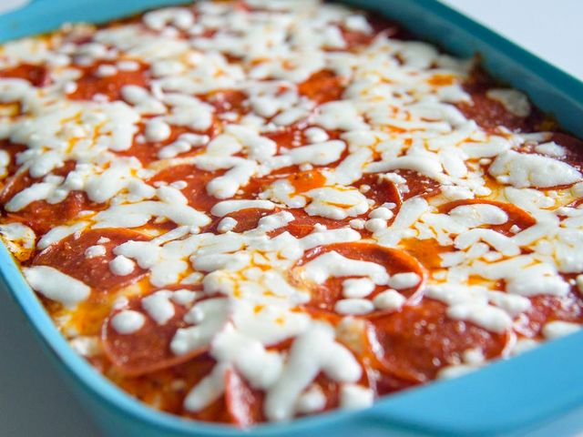close up view of Macaroni and Cheese Pizza Bake in a blue baking dish