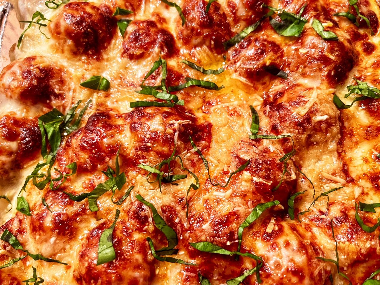 Close up of meatball sub casserole garnished with basil