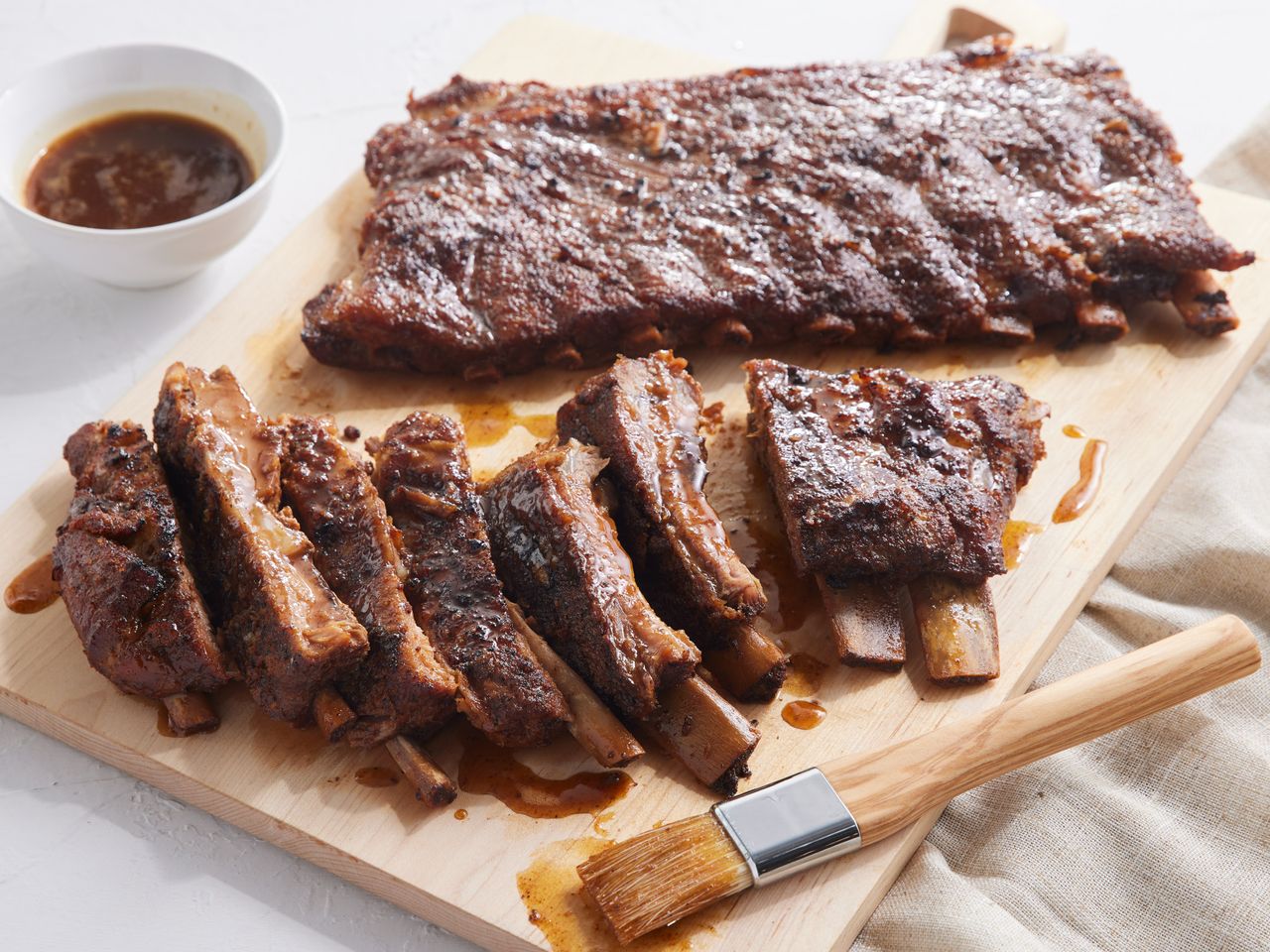 A cutting board with two racks of pork spare ribs