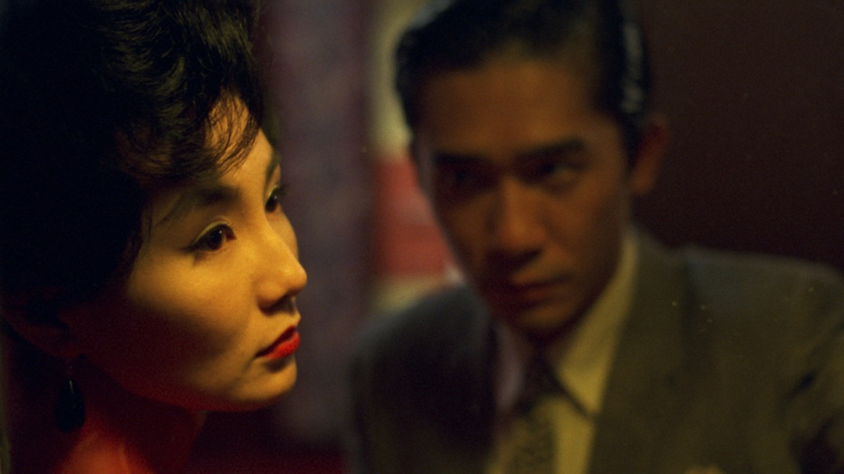 A woman turns away while a man looks at her intently in