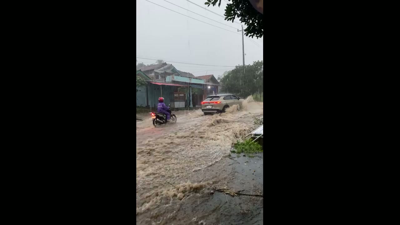 Fast-moving floodwaters sweep across Bojong–Guci highway in Tegal ...
