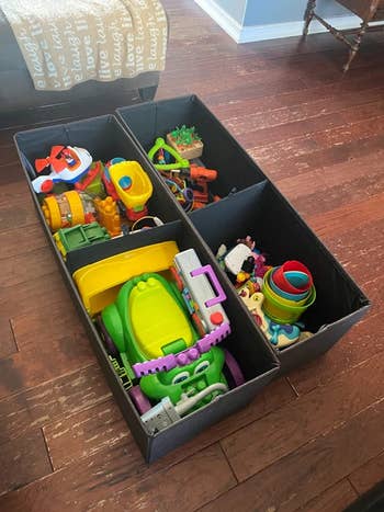 the two ottomans open, revealing all the toys inside
