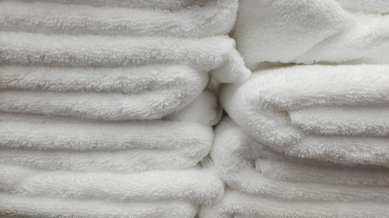 Use tension rods to create a clever towel storage solution for small ...