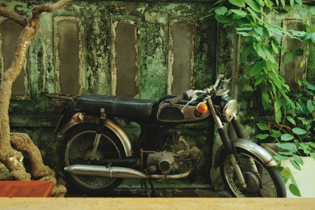 Vintage motorcycle parked against a weathered wall