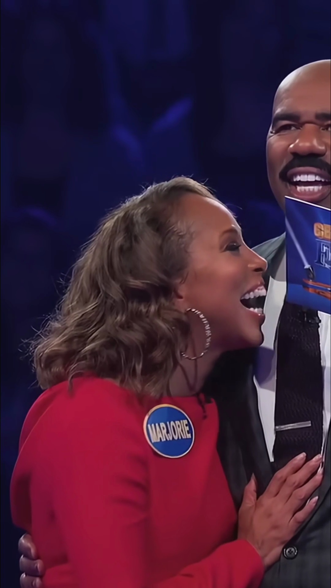 Steve hands over the podium to his wife on Celebrity Family Feud