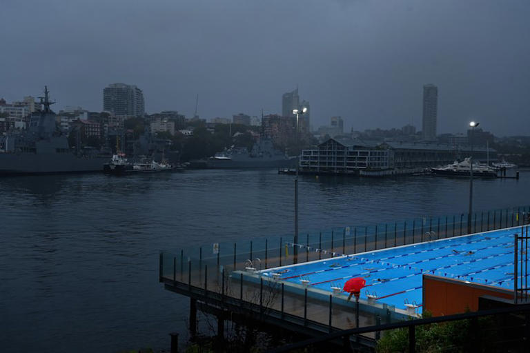 Swimmers do laps at the Andrew (Boy) Charlton pool despite the rain on Friday morning.