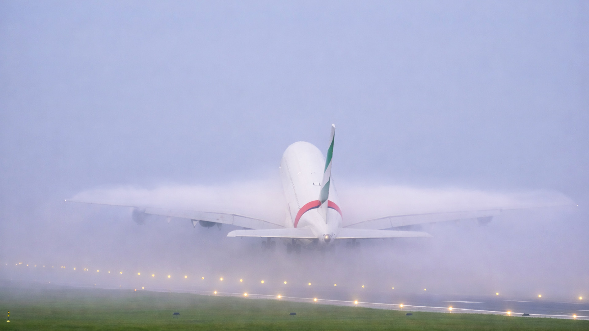 Heavy jet takeoff creates huge cloud of condensation