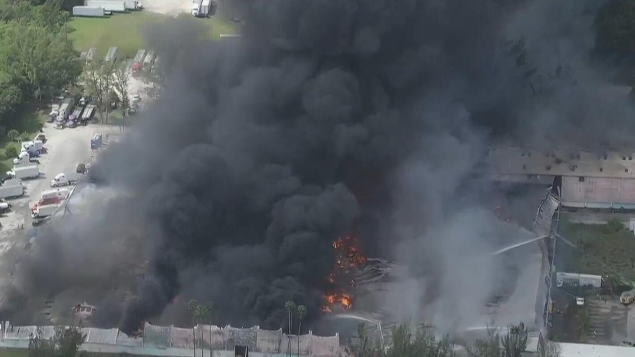 Crews race to extinguish massive warehouse fire in northwest Miami-Dade