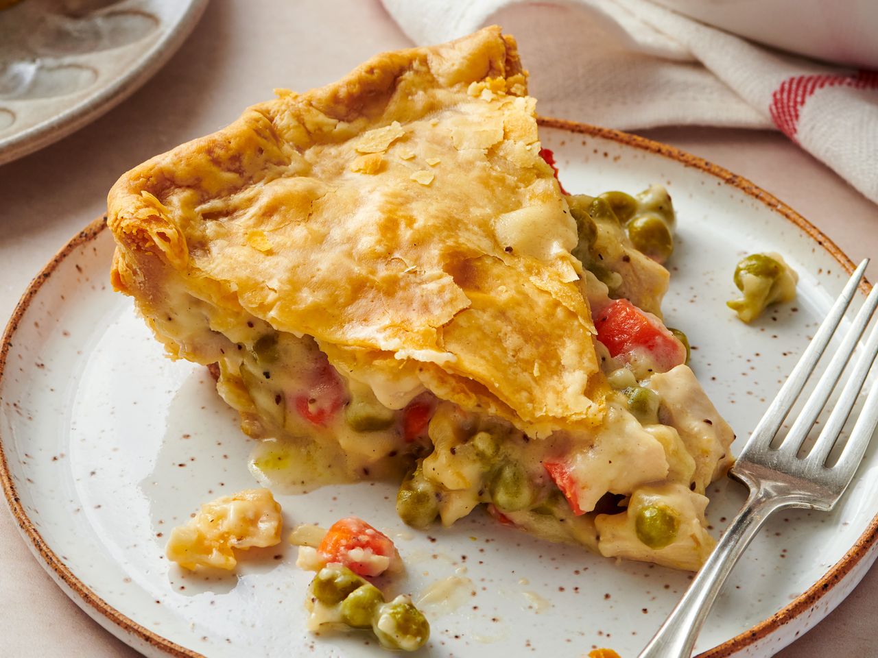 Slice of chicken pot pie with a fork on a plate
