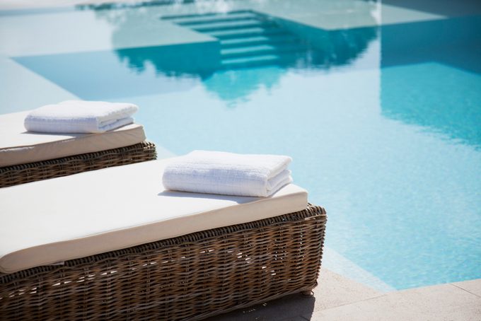 Folded Towels On Lounge Chairs Beside Pool