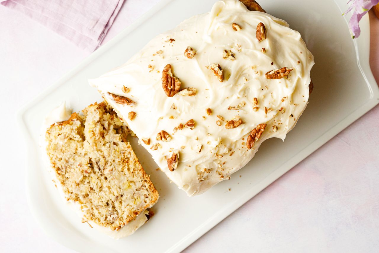 Southern Living Hummingbird Bread sliced on a platter to serve topped with pecans
