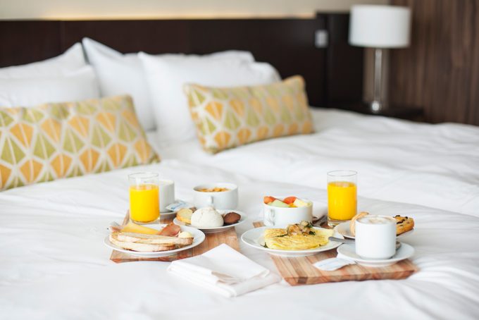 Breakfast Trays On Bed In Luxury Hotel Room