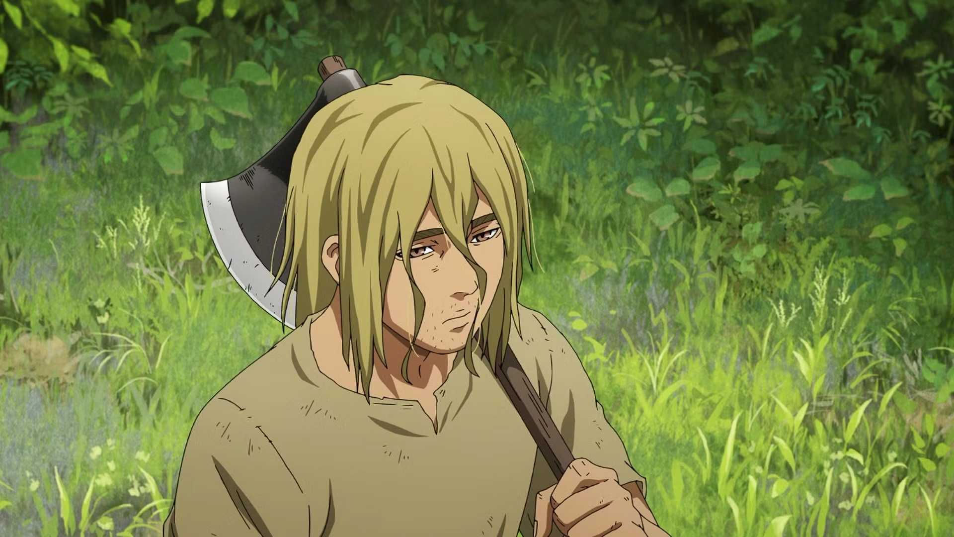 A sad looking Thorfinn holds an axe in the woods in Vinland Saga