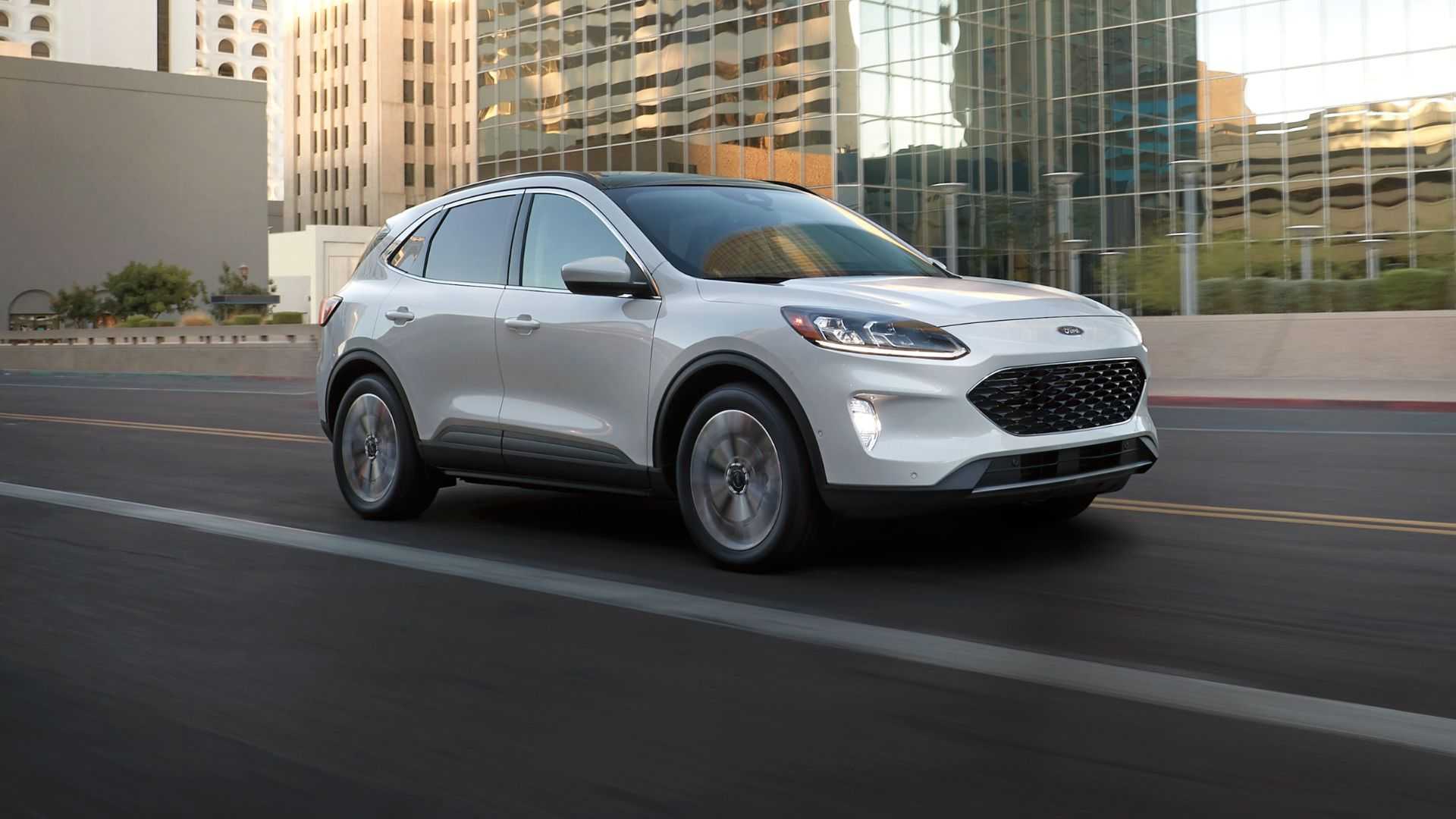 Dynamic front 3/4 shot of a white 2022 Ford Escape driving in a city.
