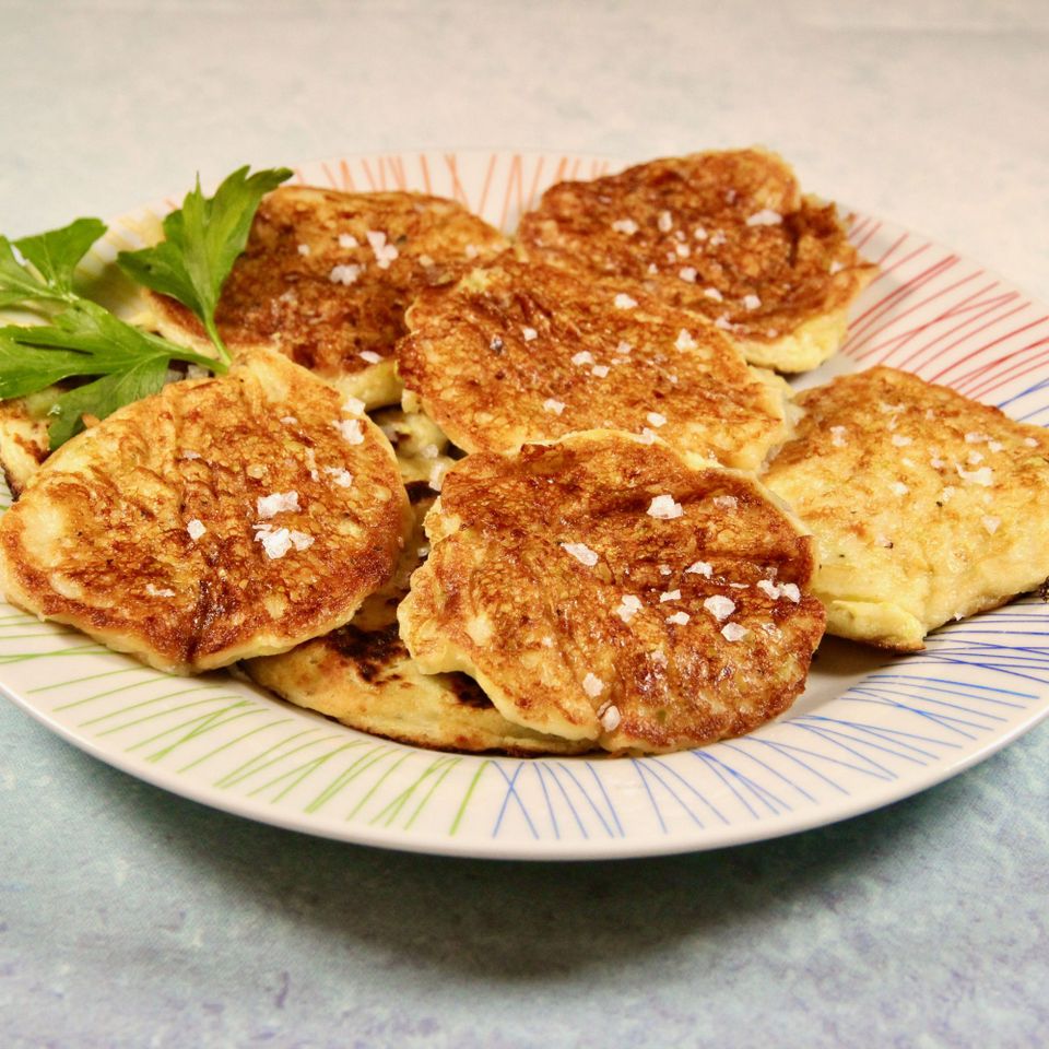 squash fritters on plate with green garnish