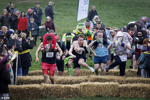 Couples take part in the UK's wife-carrying race on International Women ...
