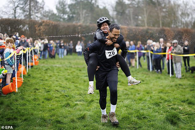 Couples take part in the UK's wife-carrying race on International Women ...