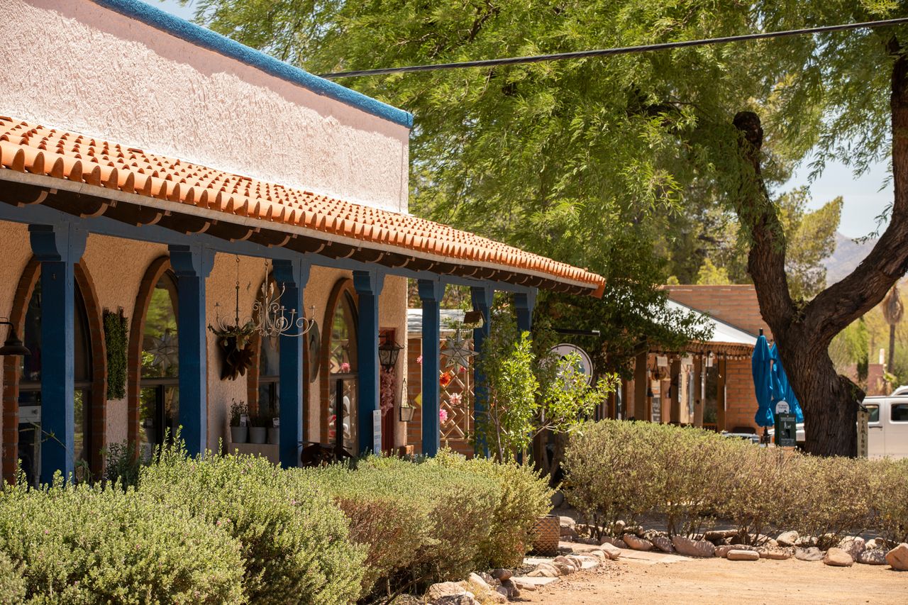 A southwesternstyle building with a tiled roof and archways surrounded by plants and trees