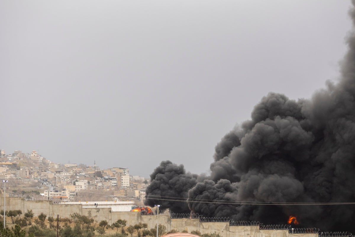 Tehran engulfed in black smoke after wave of strikes on oil depots