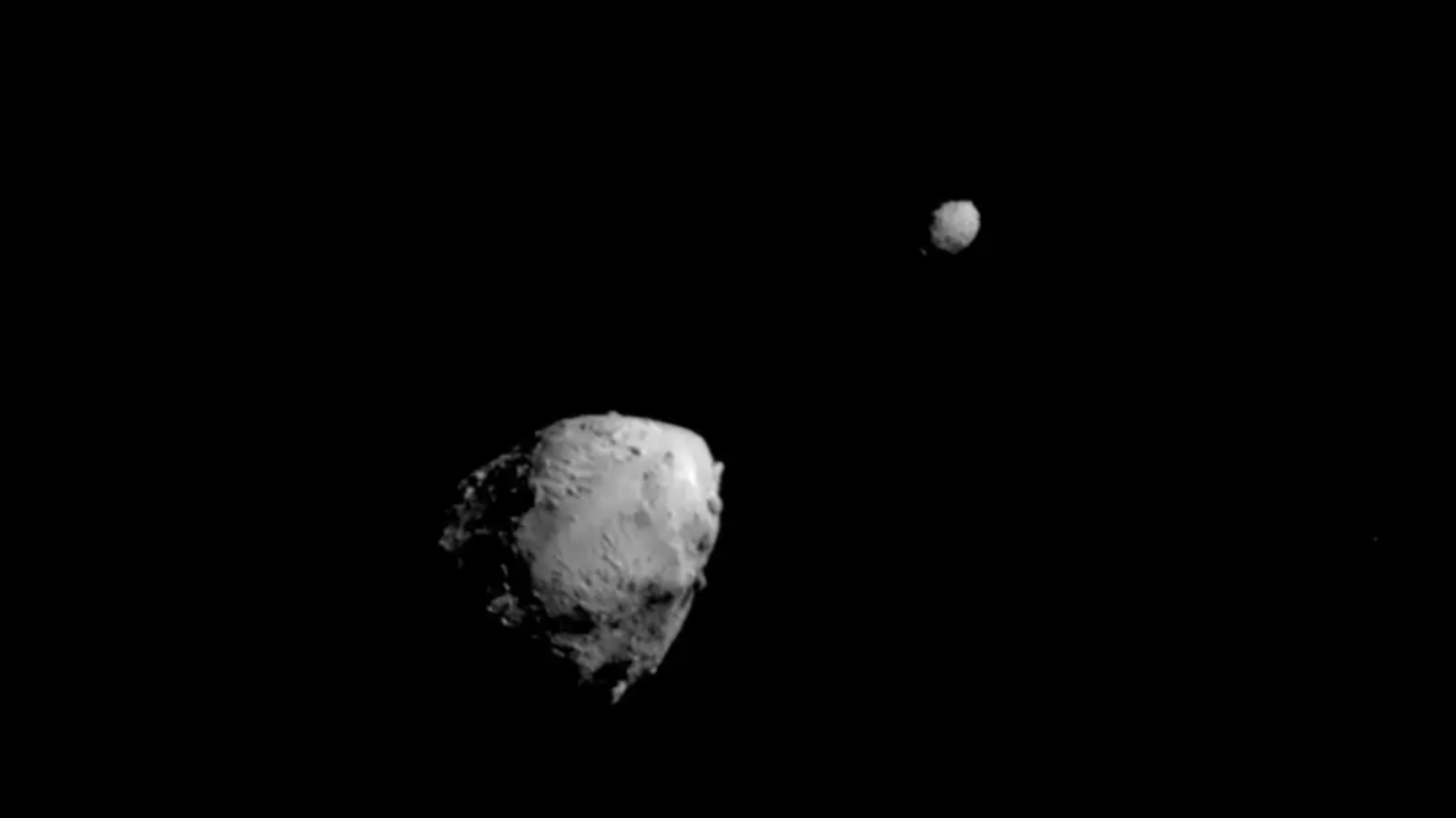 Asteroids with small moons can exchange rocks and dust in slow, gentle ...