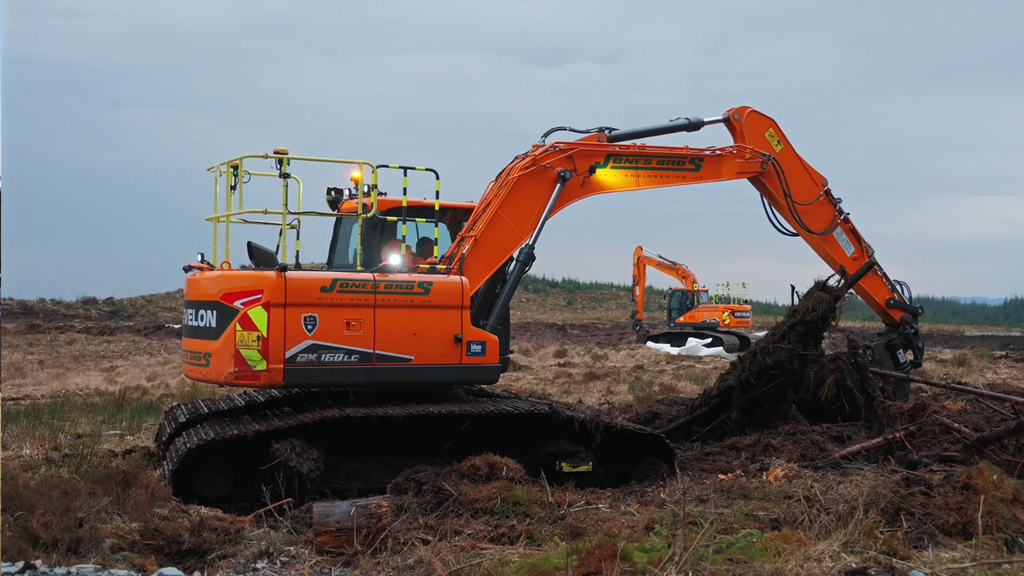 Powerful excavator pulling massive tree roots