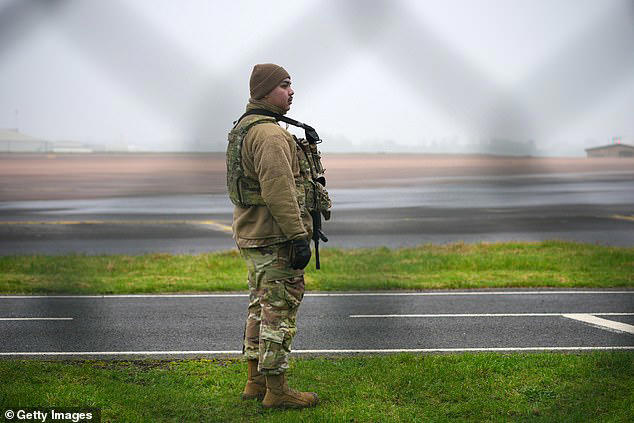 An armed airman of the US Air force guards the perimeter fence at RAF Fairford after a B1 Lancer bomber landed over the weekend