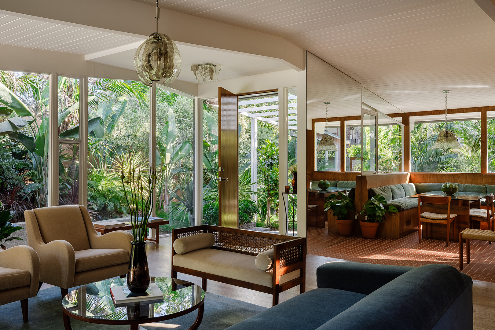 Living room with large windows and lots of greenery outside