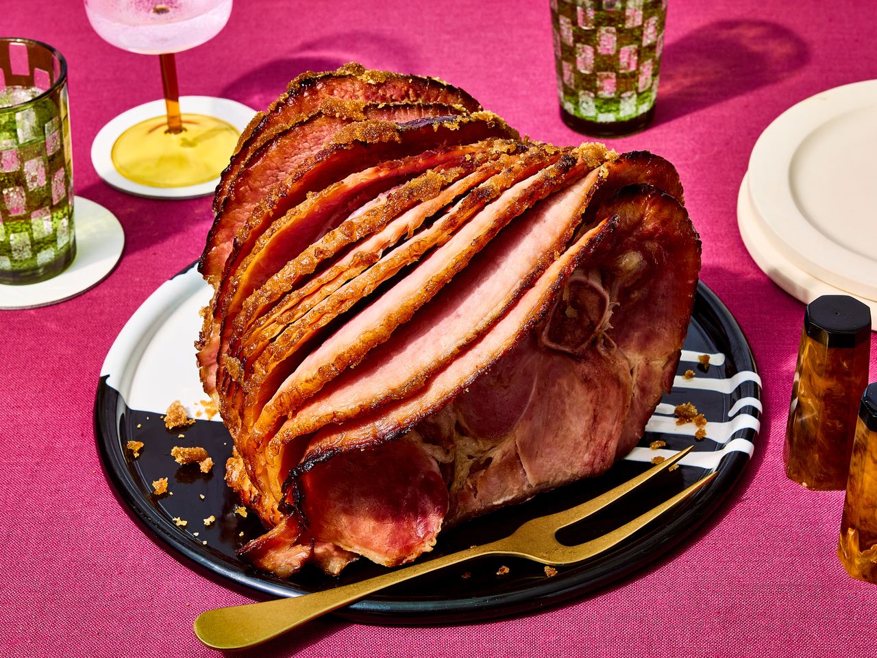 Slow cooker ham on a black and white platter.