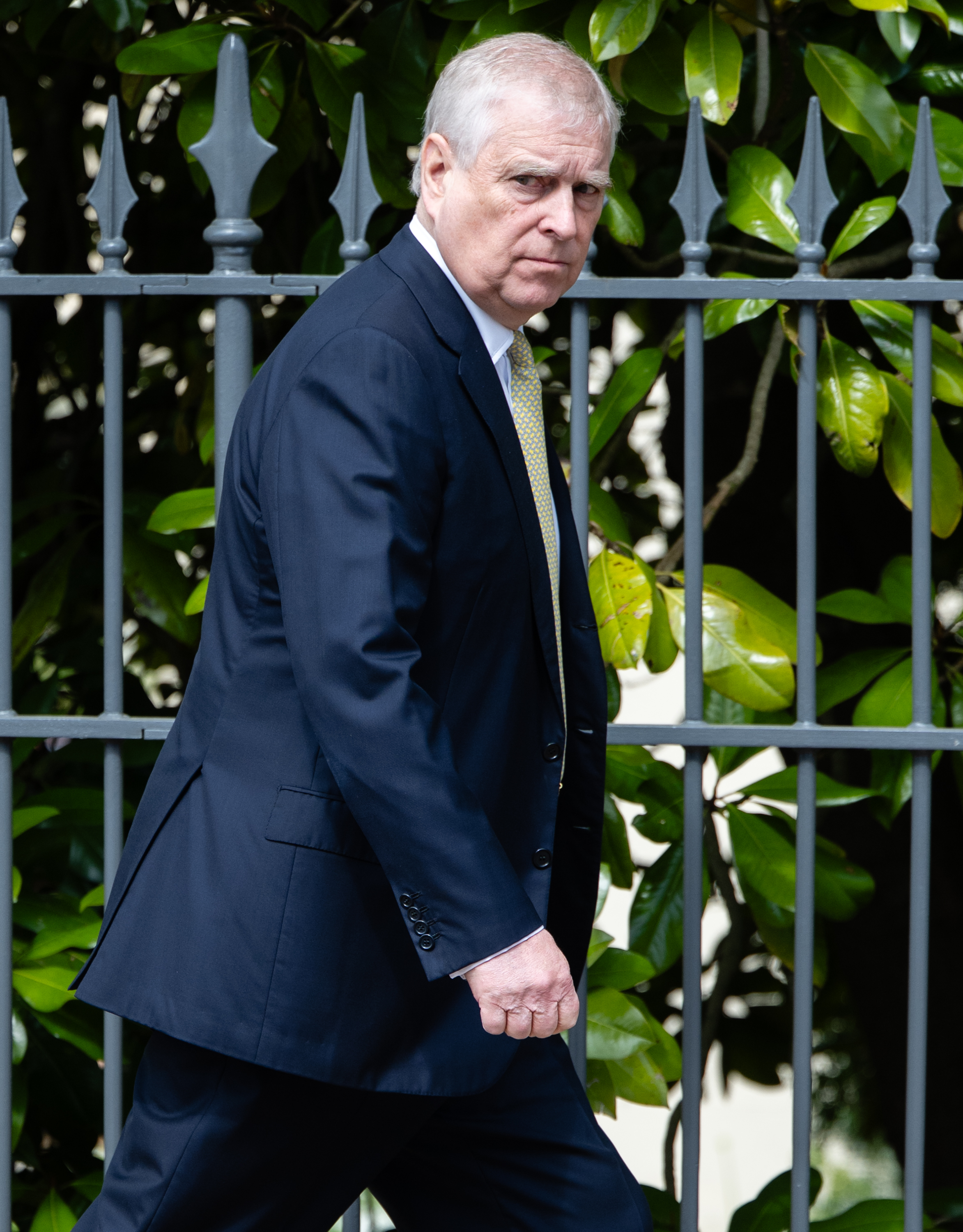Prince Andrew walking outside in a suit.