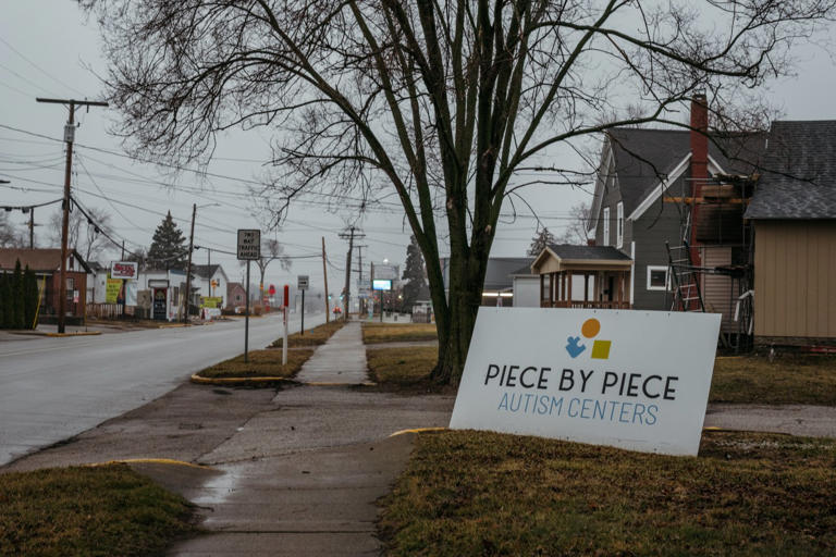 A sign at the end of a driveway leading to a Piece by Piece Autism Center.