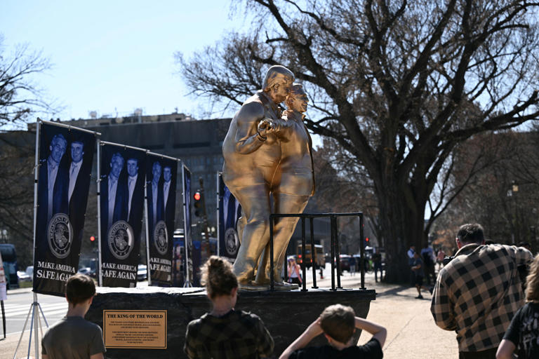 Detrás de la estatua había varias pancartas con una foto de Trump y Epstein junto a la frase “Make America Safe Again” (Hagamos que Estados Unidos vuelva a ser seguro) (AFP/Getty)