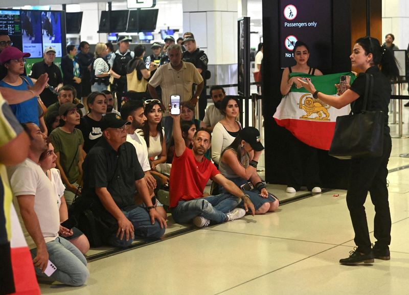 Supporters of the Iranian women's soccer team gather at Sydney Airport, after five of the players were granted asylum, in Sydney, Australia, March 10, 2026. REUTERS/Jeremy Piper
