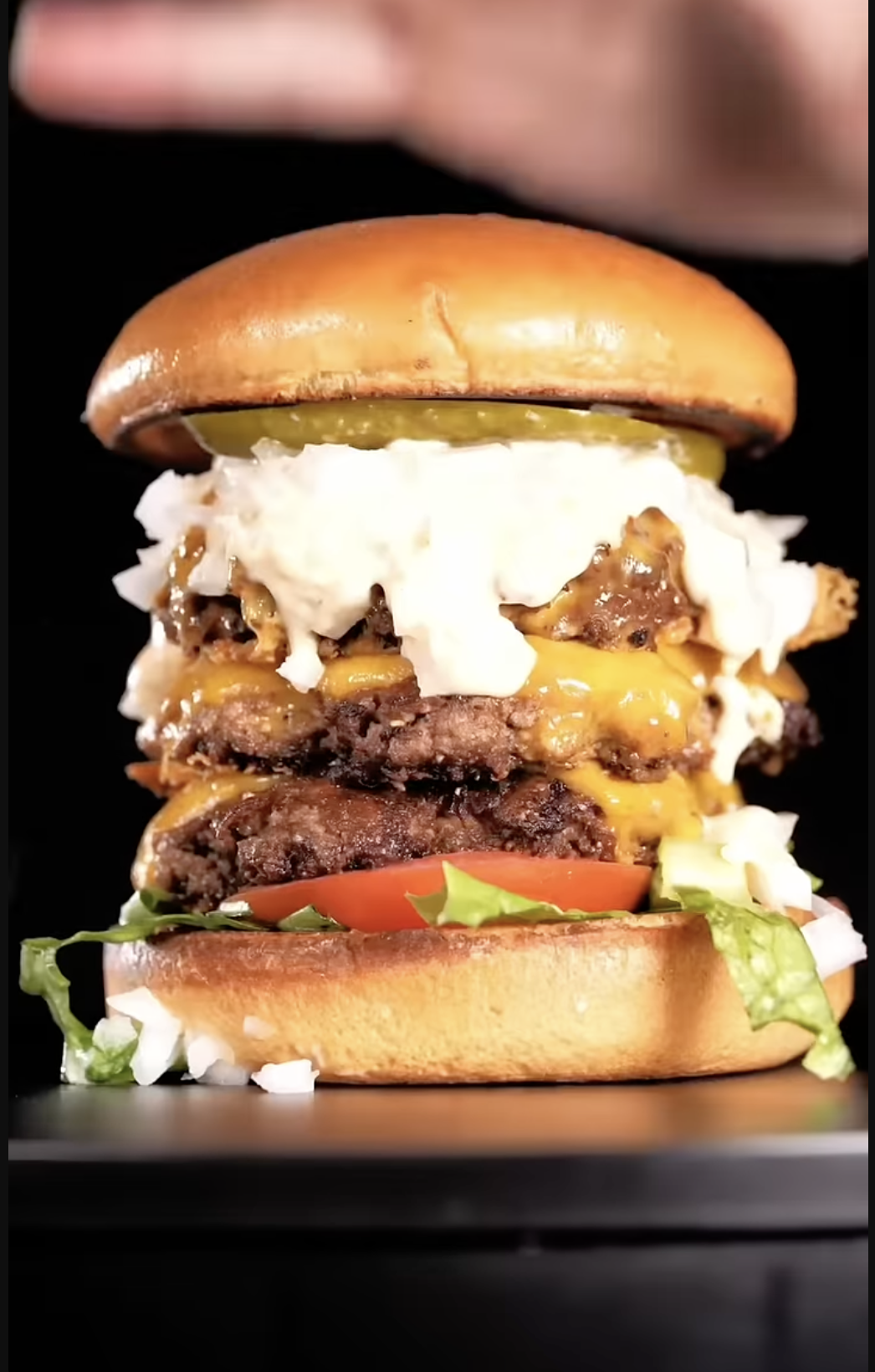 Triple cheeseburger stacked with three layers of beef and cheese