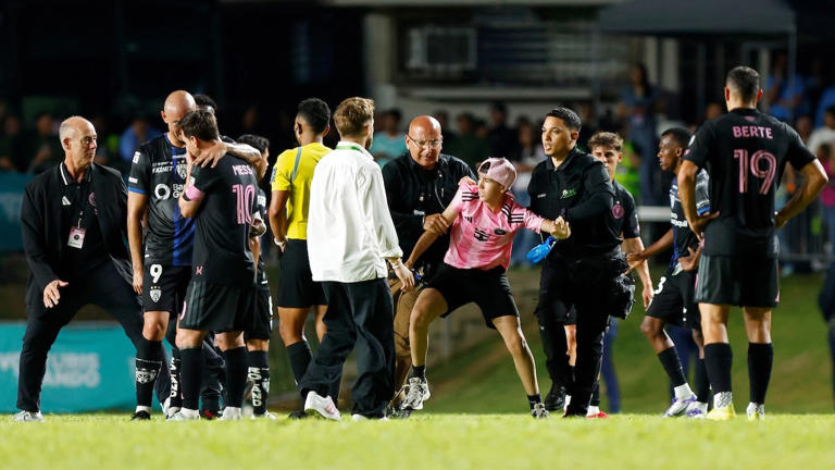 A fan is detained by security guards after jumping onto the field to greet Lionel Messi, during a friendly game between Independiente del Valle and Inter Miami on Feb. 26, 2026 in San Juan, Puerto Rico. Getty Images