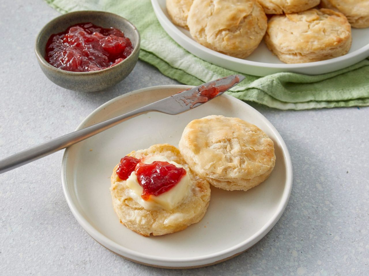 Our Favorite Buttermilk Biscuits on a plate with butter and jam
