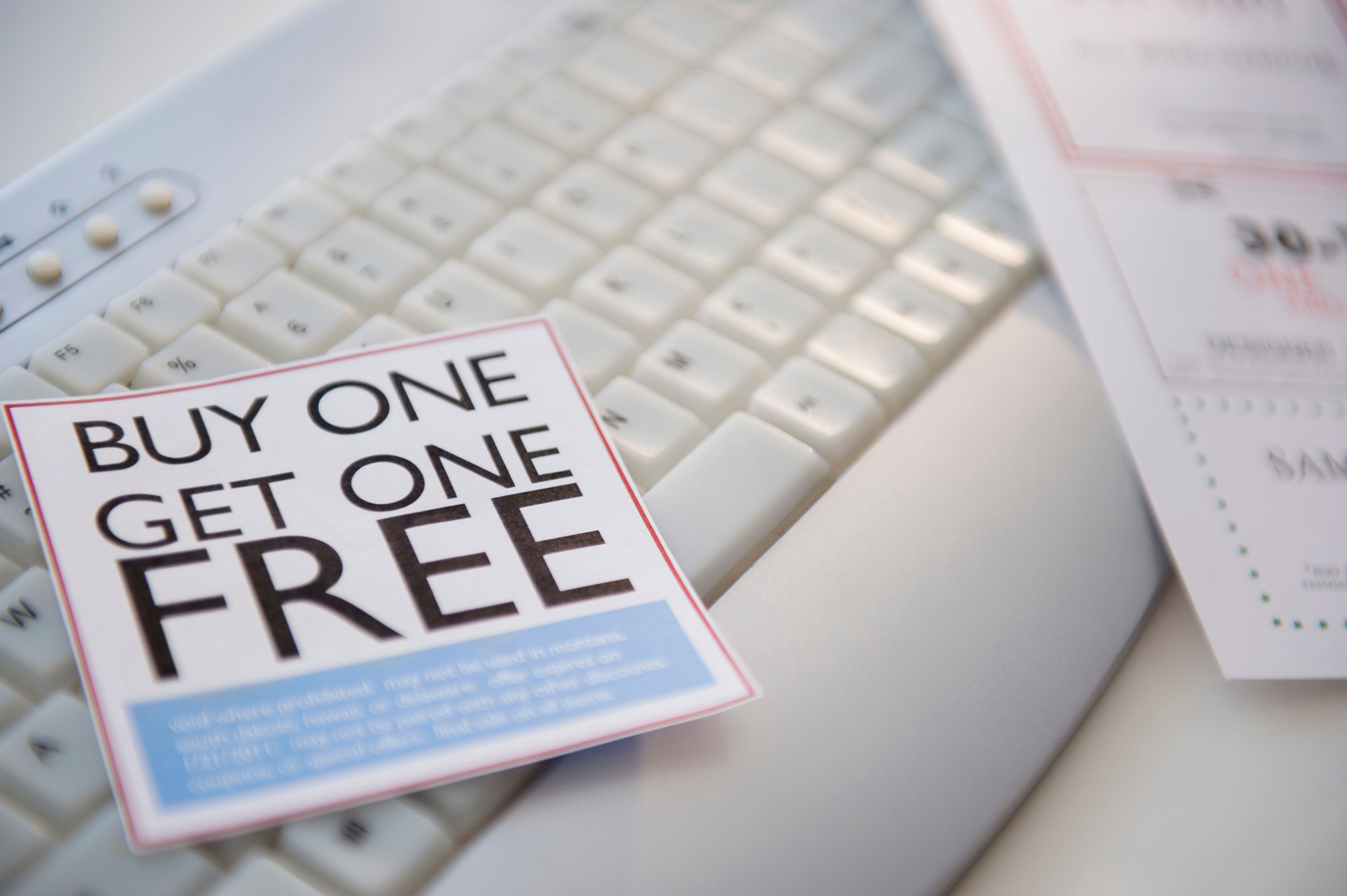 Promo card on keyboard with "Buy One Get One Free" offer, likely related to retail marketing or business strategy