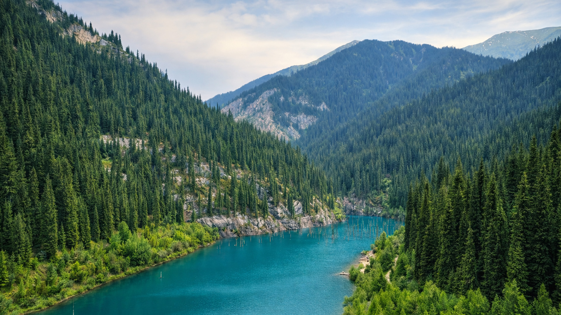 Lago turquesa oculto entre los bosques de montaña de Almaty