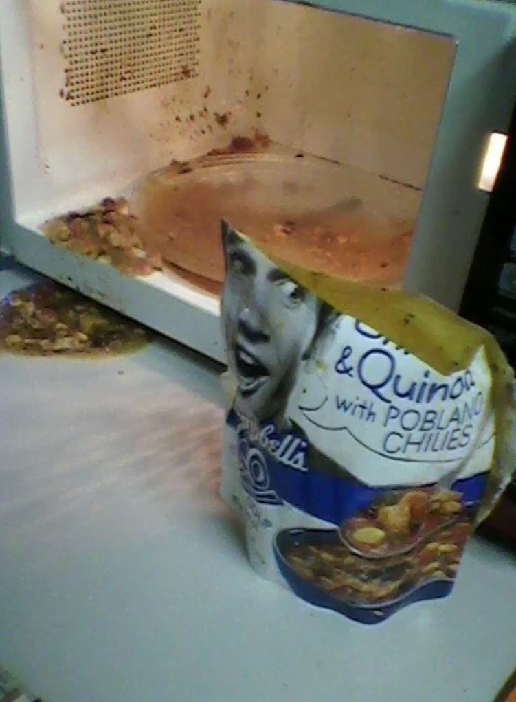 Screenshot of a Reddit post showing spilled soup in a microwave with a caption about a microwaved Campbell’s soup disaster