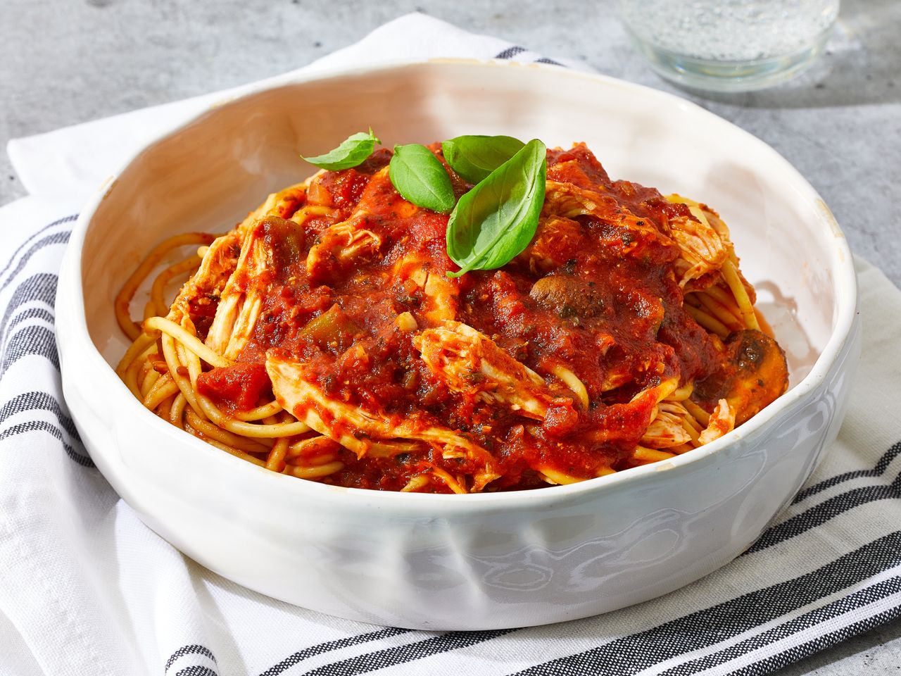 A bowl of chicken cacciatore served over spaghetti