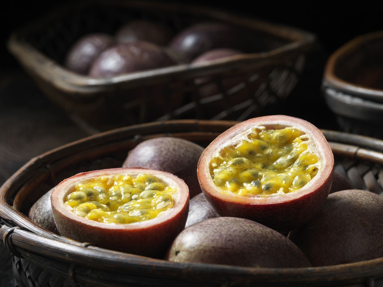 Passion fruit whole and halved in a basket