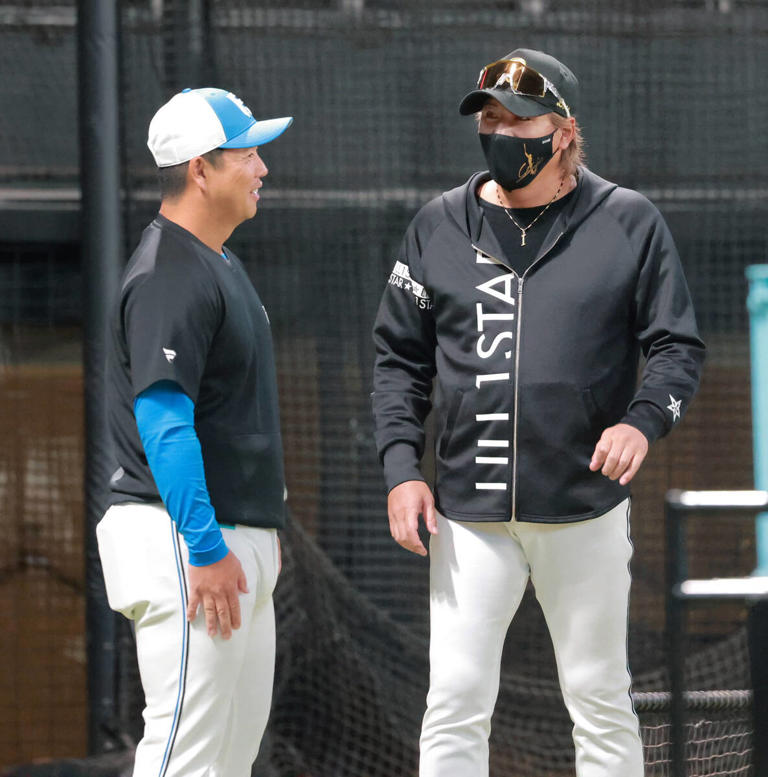 打撃練習中、横尾打撃コーチ（左）と話す新庄剛志監督