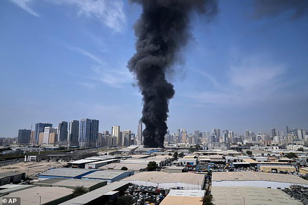 A black plume of smoke rises from a warehouse at the industrial area of Sharjah City in the United Arab Emirates