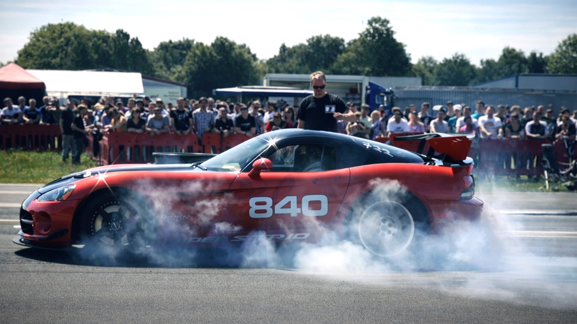 High performance cars perform dramatic donuts and burnouts