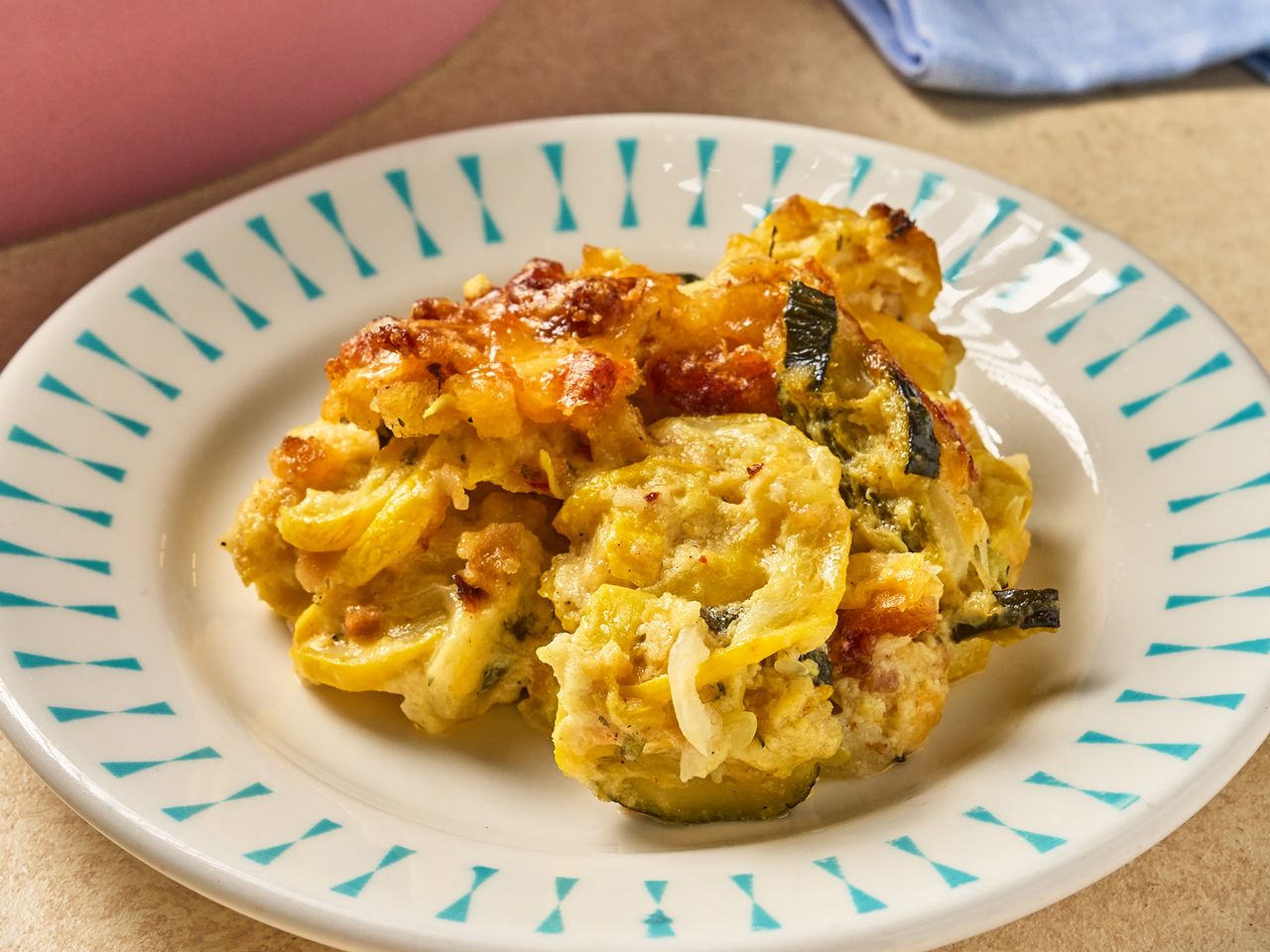 Serving of squash and zucchini casserole on a decorative plate