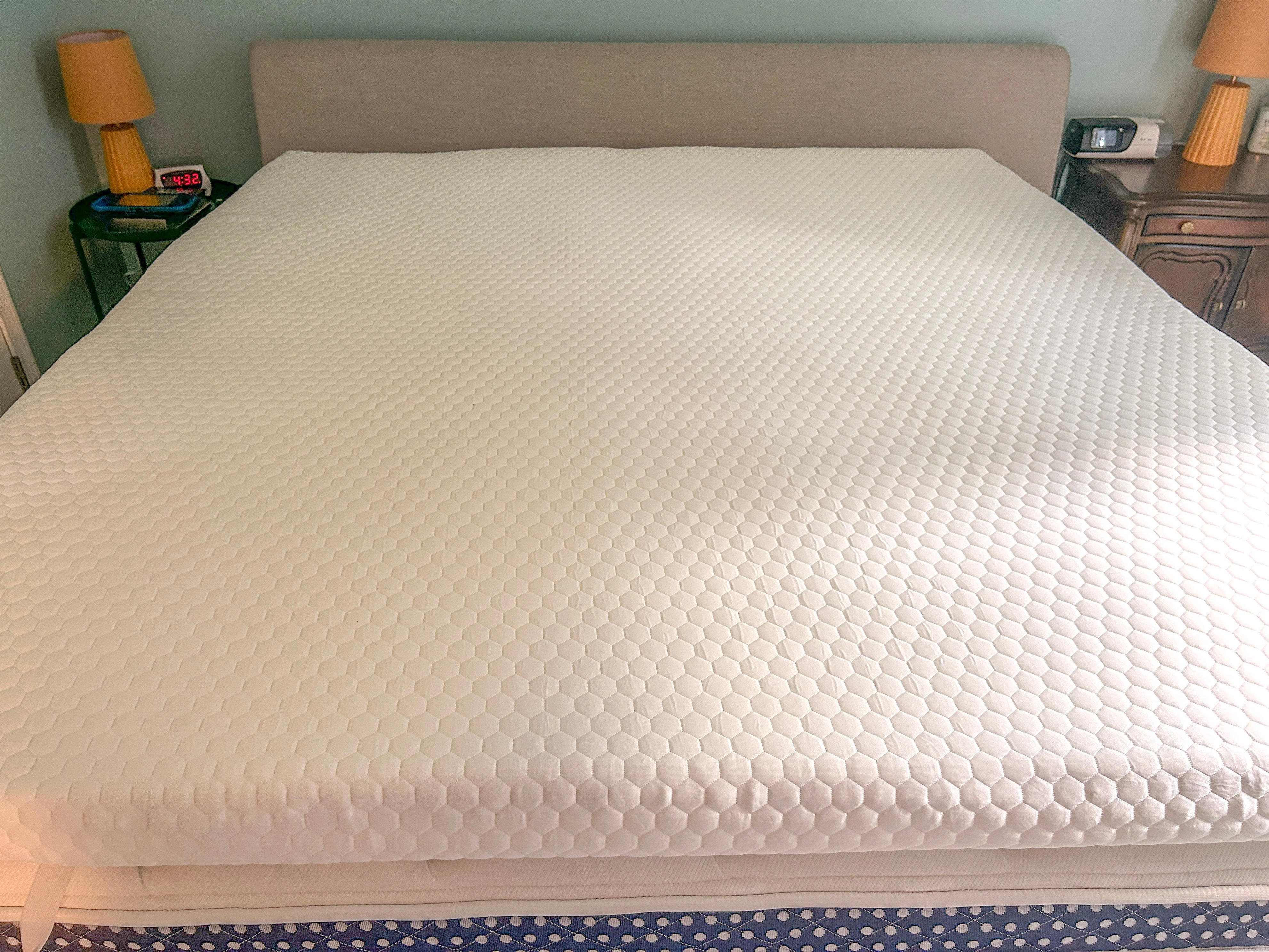 A Helix GlacioTex mattress topper on a bed inside of a blue bedroom.