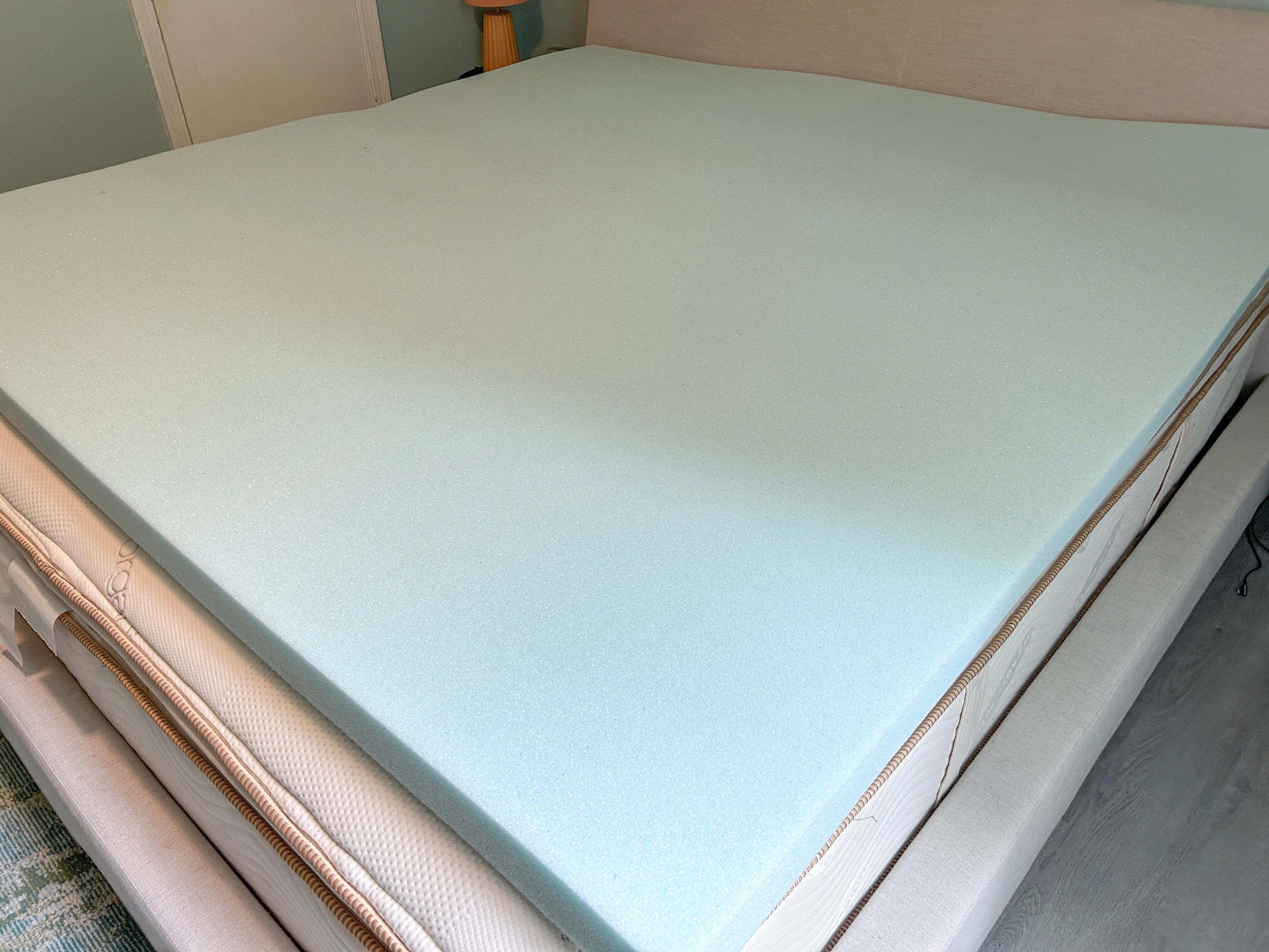 A Linenspa mattress topper sitting on top of a mattress.