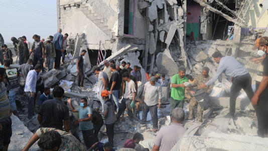 Local people and rescue workers looking for survivors in the rubble of the school