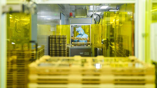 A worker operates on the production line of touchscreen glass cover at Hunan Wobo Technology Co., Ltd. on June 12, 2025 in Yongzhou, Hunan province. - Jiang Keqing/VCG/Getty Images